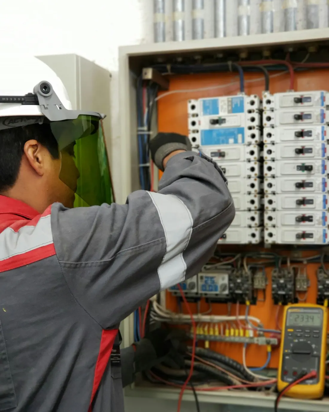 Technicien de maintenance en tenue de protection intervenant sur une armoire électrique